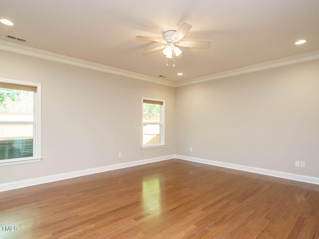spare room with ornamental molding, wood finished floors, ceiling fan, baseboards, and recessed lighting