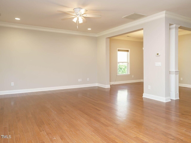 unfurnished room with a ceiling fan, wood finished floors, decorative columns, crown molding, and baseboards