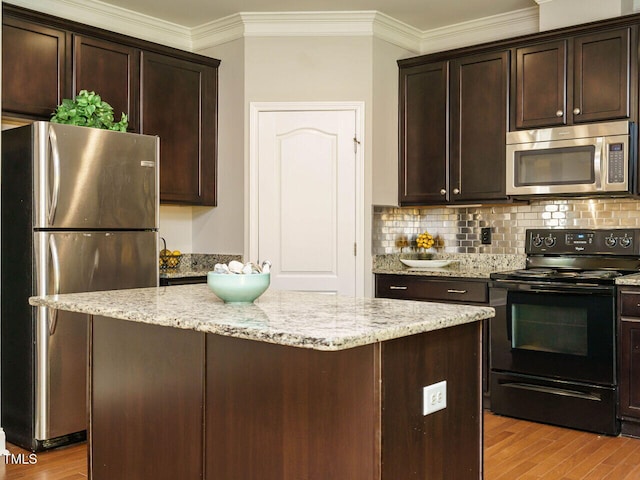kitchen featuring stainless steel appliances, wood finished floors, tasteful backsplash, crown molding, and dark brown cabinets