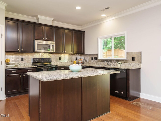 kitchen with black appliances, wood finished floors, crown molding, dark brown cabinets, and recessed lighting