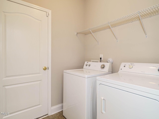 laundry area featuring independent washer and dryer, baseboards, and tile patterned floors