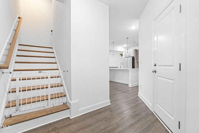 staircase with recessed lighting, baseboards, and wood finished floors