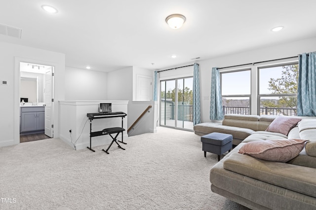 carpeted living area featuring visible vents, baseboards, and recessed lighting
