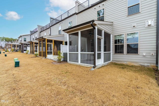 rear view of house with a yard and a sunroom