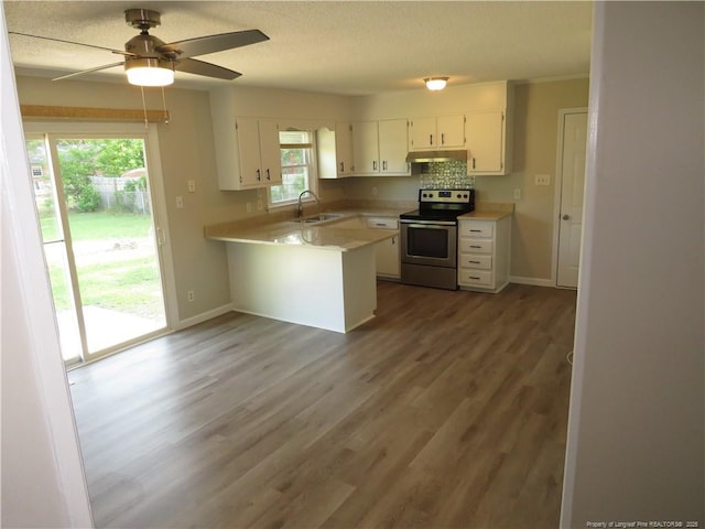 6324 Brussels Ct, Fayetteville, NC 28304 - kitchen with under cabinet range hood, white cabinetry, a peninsula, stainless steel range with electric stovetop, and light countertops