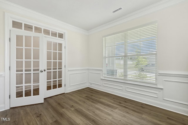 unfurnished room with french doors, a decorative wall, crown molding, wainscoting, and dark wood-style flooring