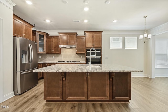 kitchen featuring stainless steel appliances, under cabinet range hood, crown molding, light wood finished floors, and baseboards