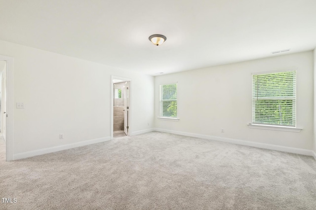 carpeted empty room with healthy amount of natural light and baseboards