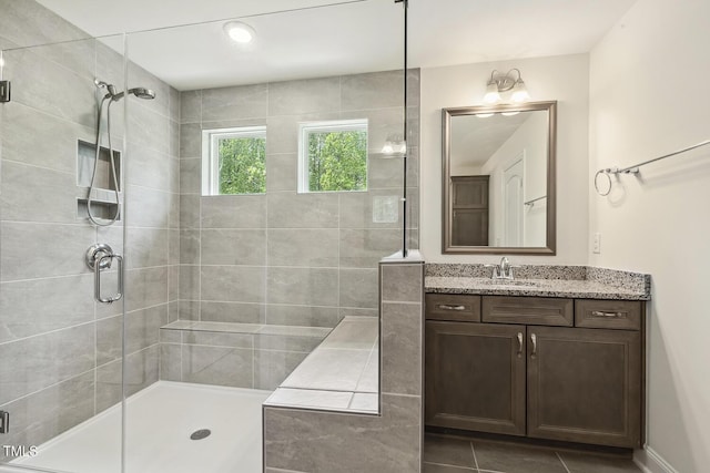 full bathroom with a stall shower, vanity, and tile patterned flooring
