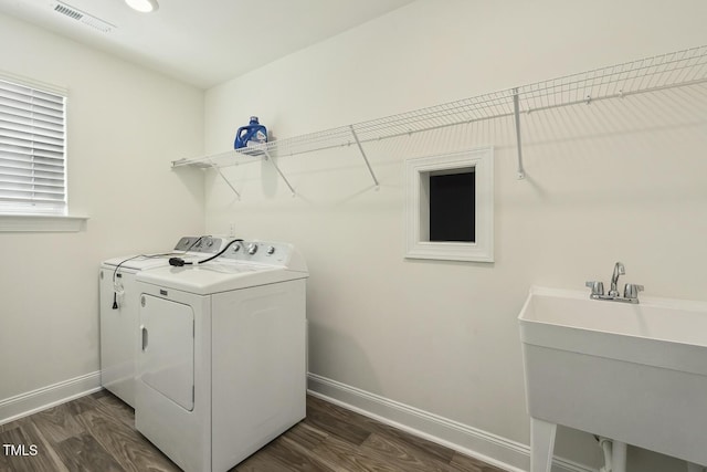 laundry area with washing machine and clothes dryer, baseboards, and dark wood finished floors