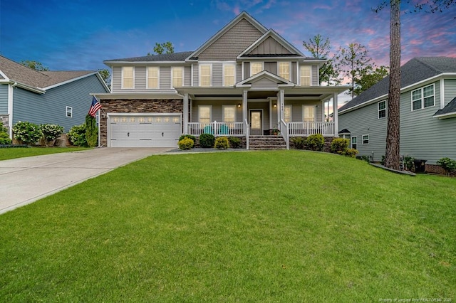 craftsman house featuring stone siding, a garage, concrete driveway, a front yard, and a porch
