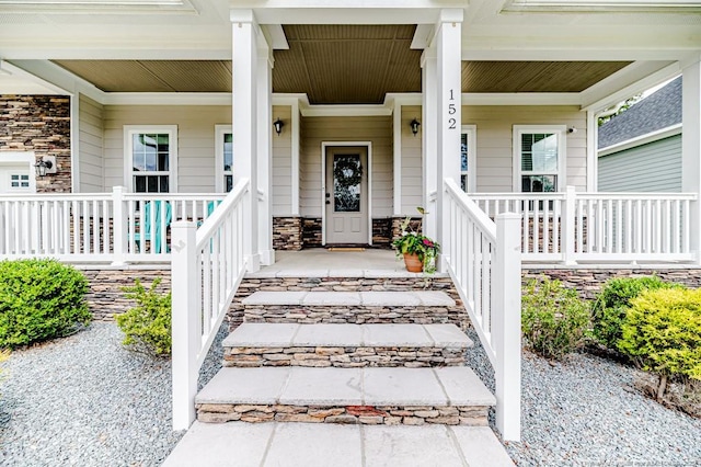property entrance featuring covered porch and stone siding