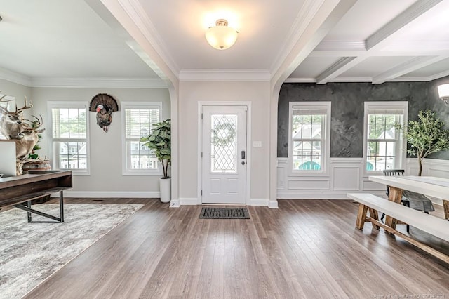 entrance foyer featuring a wealth of natural light, beam ceiling, crown molding, and wood finished floors