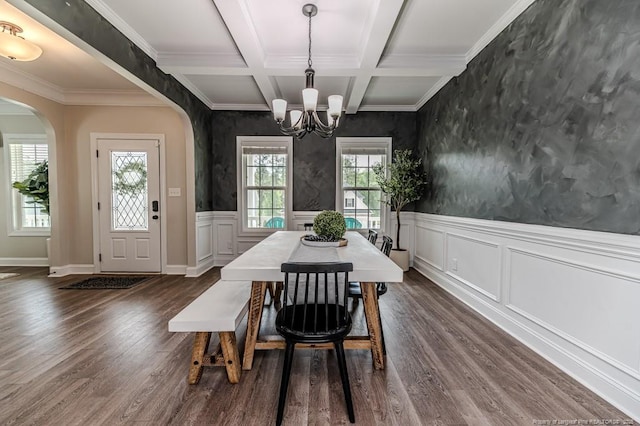 dining area with an inviting chandelier, dark wood-style flooring, arched walkways, beamed ceiling, and coffered ceiling