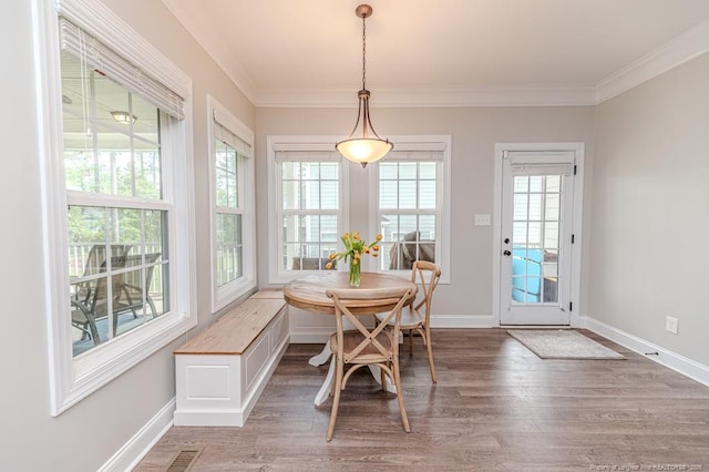dining space featuring crown molding, a wealth of natural light, and wood finished floors