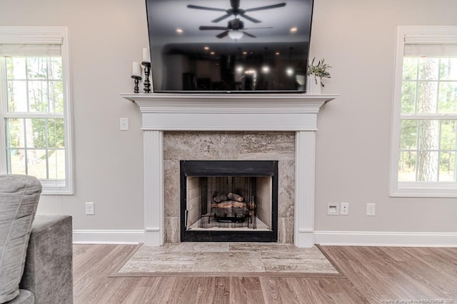 details with wood finished floors, a fireplace, baseboards, and ceiling fan