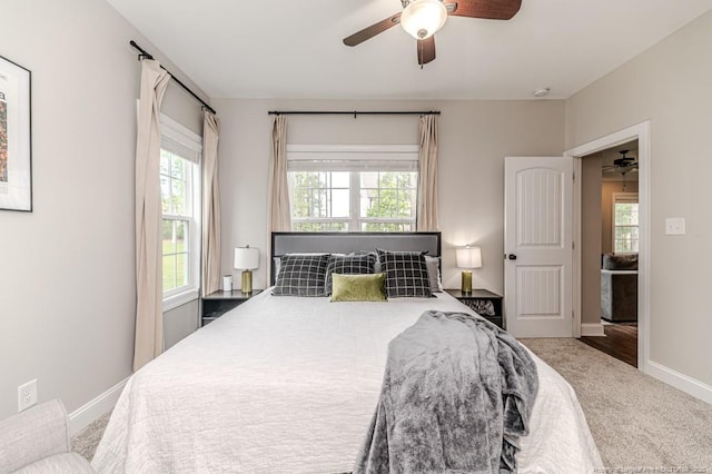 bedroom featuring baseboards, multiple windows, ceiling fan, and carpet