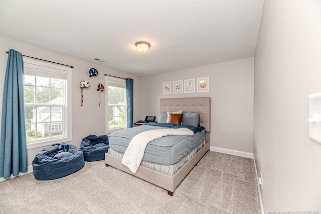 carpeted bedroom featuring baseboards and visible vents