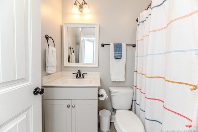 full bath featuring toilet, a shower with shower curtain, and vanity