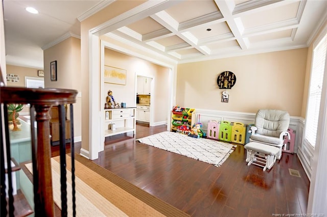 game room with a wainscoted wall, dark wood-style flooring, crown molding, beamed ceiling, and coffered ceiling