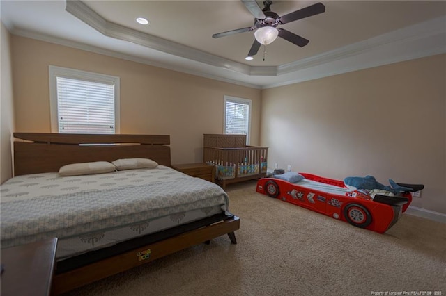 bedroom with crown molding, a raised ceiling, and carpet floors