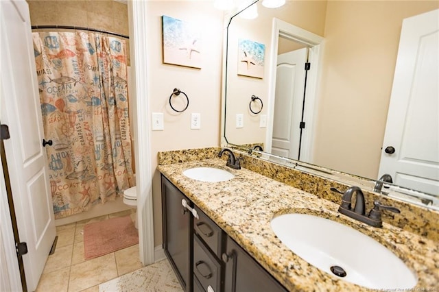 bathroom with a sink, double vanity, toilet, and tile patterned floors