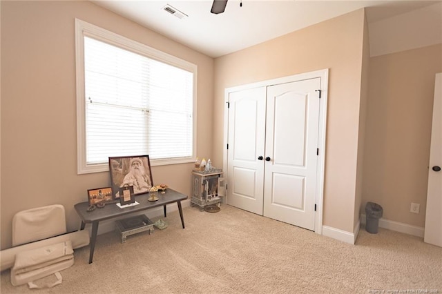 living area with carpet flooring, baseboards, a ceiling fan, and visible vents