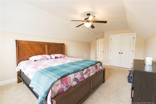 bedroom featuring a closet, vaulted ceiling, light carpet, a ceiling fan, and baseboards