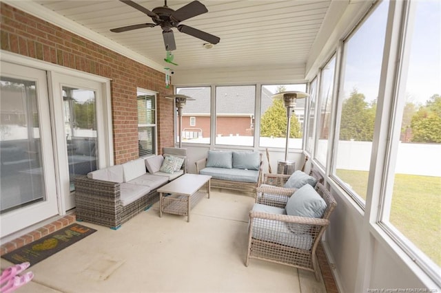 sunroom featuring a ceiling fan and an outdoor living space