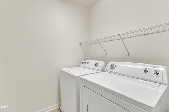 clothes washing area featuring washing machine and dryer and baseboards