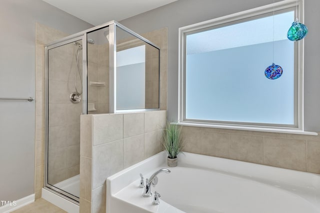 full bathroom with a shower stall and a bath