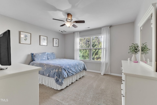 bedroom featuring light colored carpet, baseboards, and ceiling fan