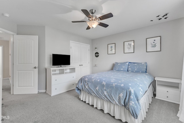 carpeted bedroom with a closet, a ceiling fan, and baseboards