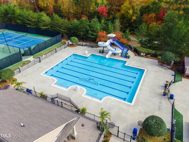 community pool with a water slide and fence