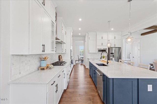kitchen with appliances with stainless steel finishes, a sink, blue cabinetry, white cabinets, and recessed lighting