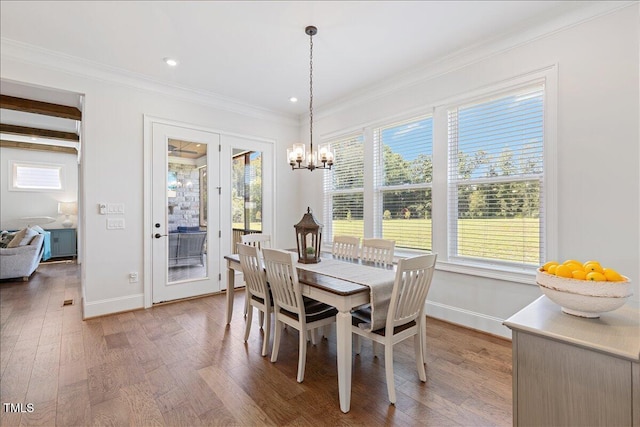 dining room featuring baseboards, wood finished floors, a chandelier, crown molding, and recessed lighting