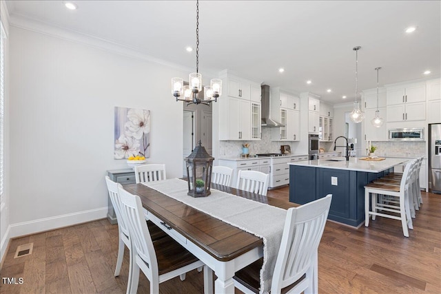 dining room featuring a chandelier, ornamental molding, recessed lighting, baseboards, and dark wood-type flooring