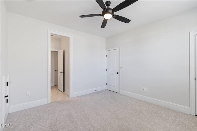 unfurnished bedroom with light colored carpet and baseboards