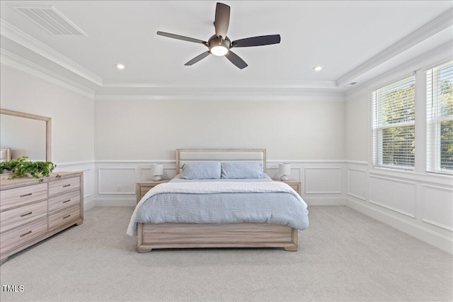 bedroom with light colored carpet, a decorative wall, a wainscoted wall, ornamental molding, and ceiling fan