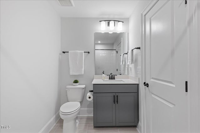 bathroom featuring toilet, vanity, a shower, baseboards, and tile patterned floors