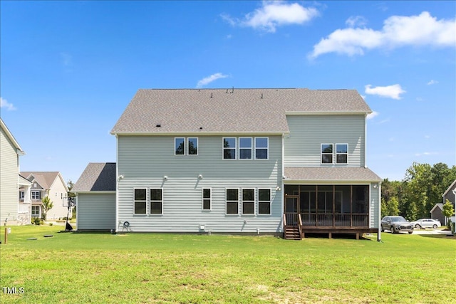 rear view of house featuring a sunroom, a lawn, and a shingled roof