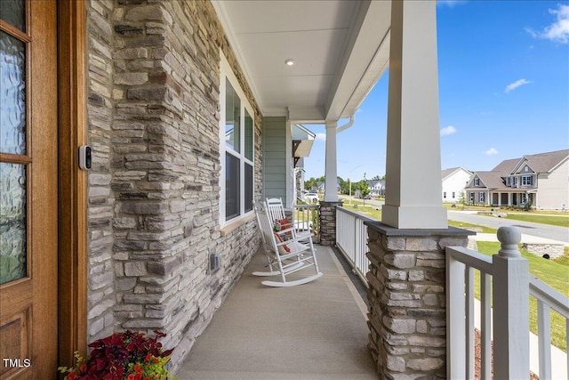 balcony featuring covered porch and a residential view
