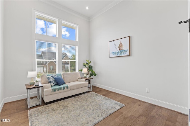 sitting room with crown molding, baseboards, light wood-style floors, and recessed lighting