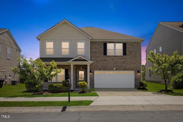 833 Ember Dr, Durham, NC 27703 - view of front of house featuring an attached garage, brick siding, driveway, and a yard