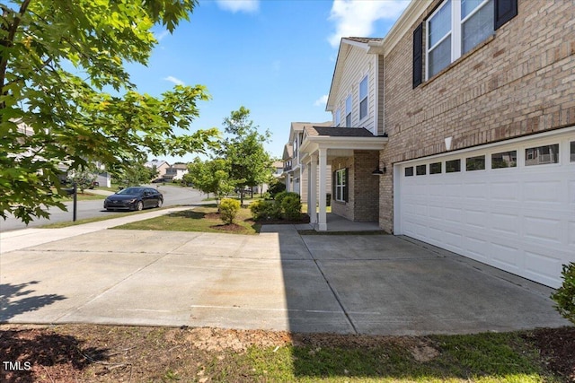 833 Ember Dr, Durham, NC 27703 - view of side of property featuring concrete driveway, a garage, and brick siding