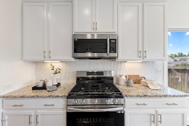 833 Ember Dr, Durham, NC 27703 - kitchen featuring stainless steel appliances, white cabinetry, decorative backsplash, and light stone counters