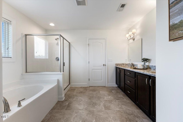 833 Ember Dr, Durham, NC 27703 - bathroom with a garden tub, double vanity, a shower stall, and baseboards