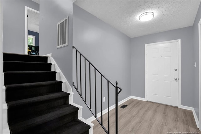 1618 Hickory Ridge Ct, Fayetteville, NC 28304 - foyer entrance with wood finished floors, stairs, a textured ceiling, and baseboards