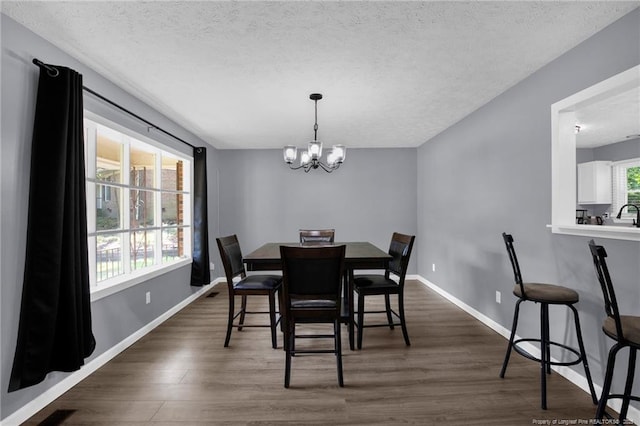 1618 Hickory Ridge Ct, Fayetteville, NC 28304 - dining area with a textured ceiling, a chandelier, dark wood-type flooring, and baseboards