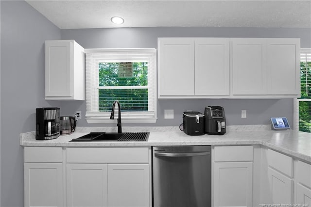 1618 Hickory Ridge Ct, Fayetteville, NC 28304 - kitchen featuring stainless steel dishwasher, a sink, white cabinets, and a textured ceiling